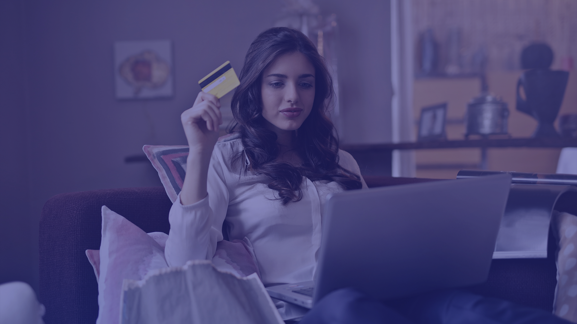 Mulher segurando cartão de crédito e notebook