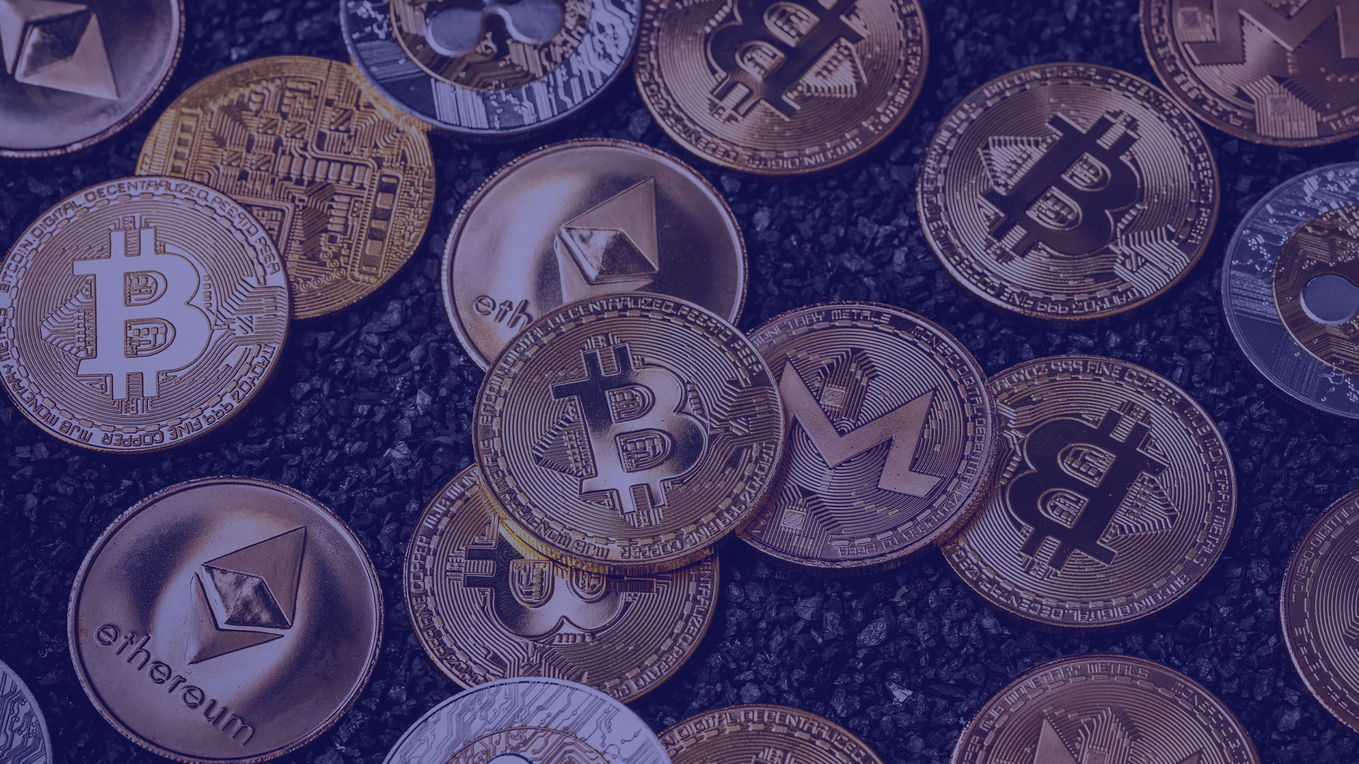 Moedas espalhadas com símbolos de diversas criptomoedas