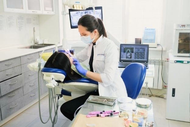 Dentista atendendo paciente em consultório da Dentalis Santo Amaro
